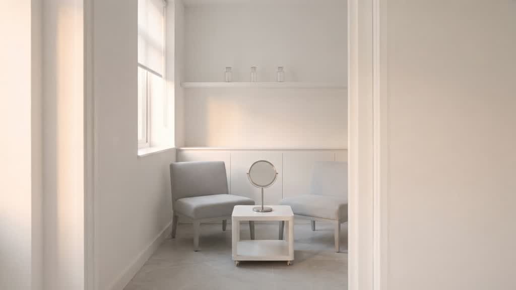 My white consulting room from the doorway, the round mirror on the table catching the window light