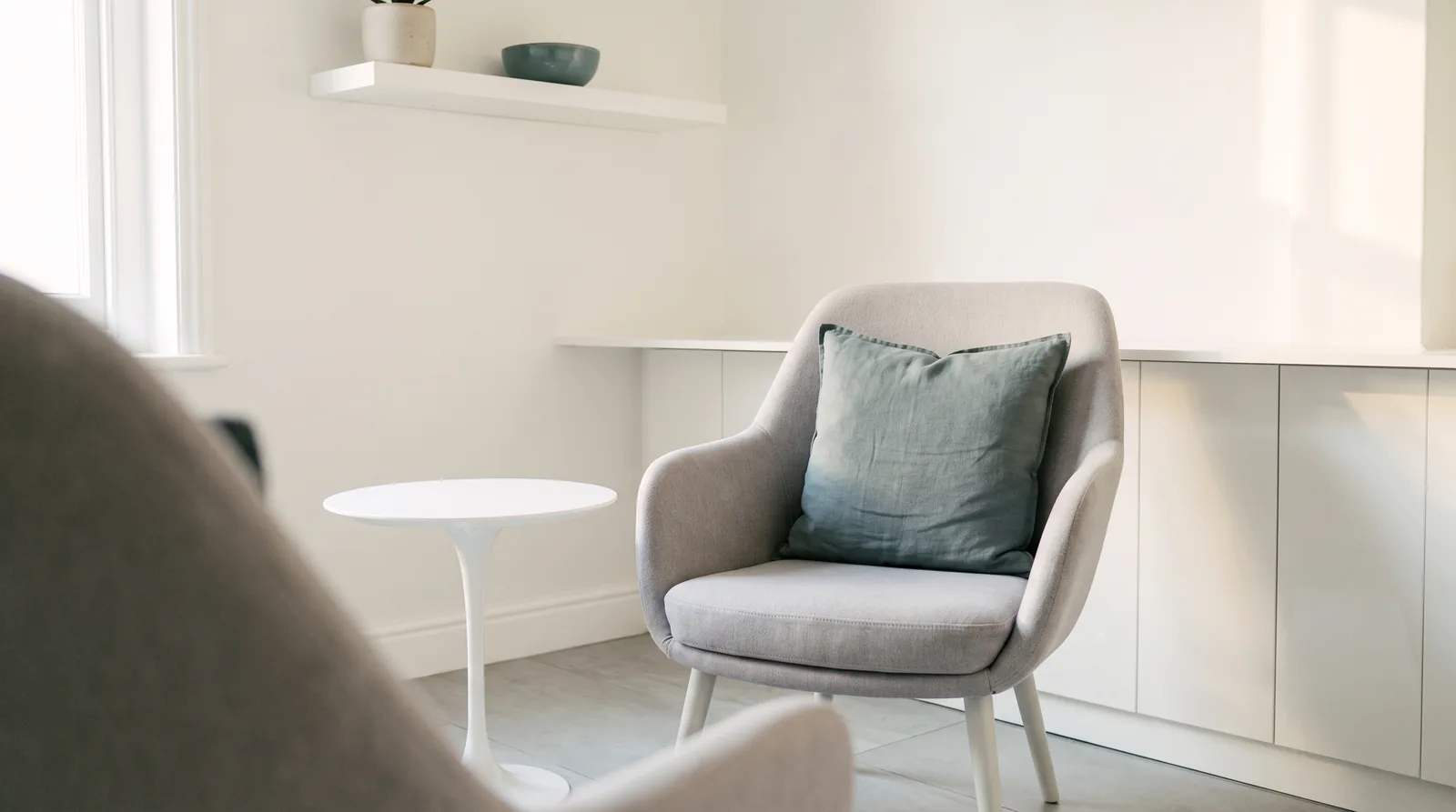 One pale grey chair drawn out from the table for someone to sit
