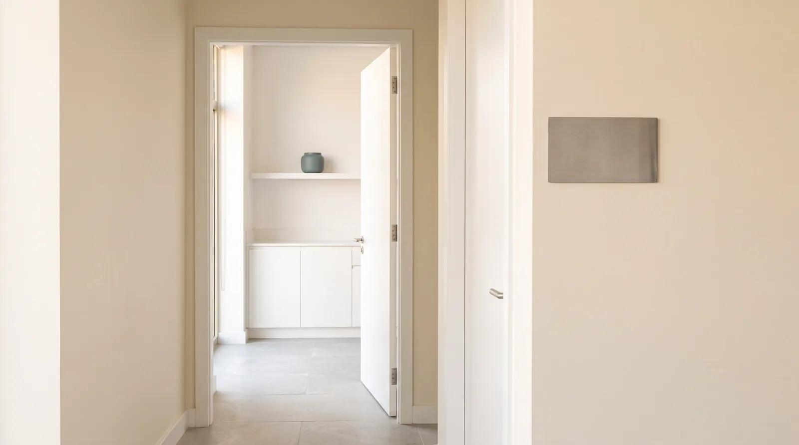 A white door standing half open onto the room, warm light through the gap