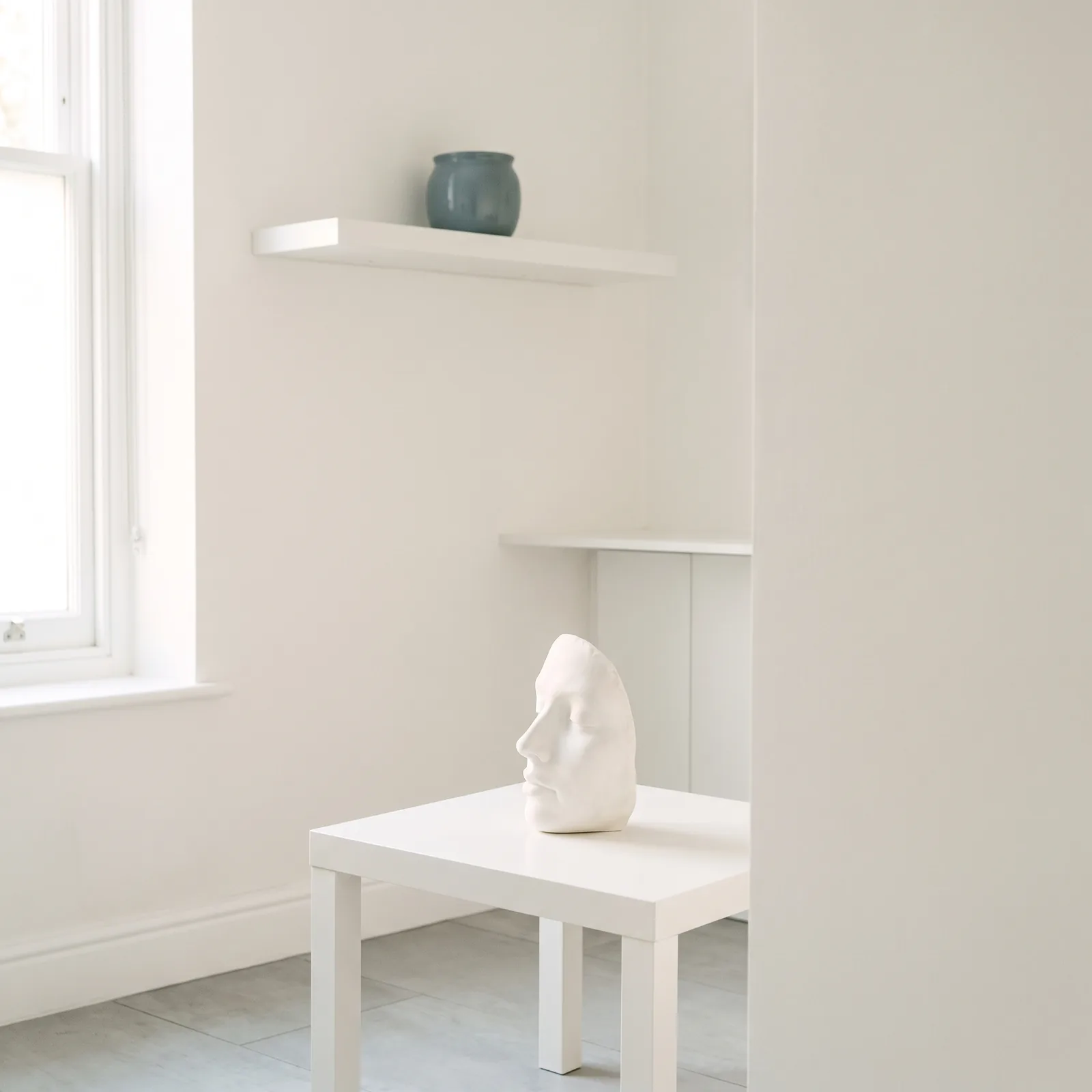A small white plaster study of a face on my table