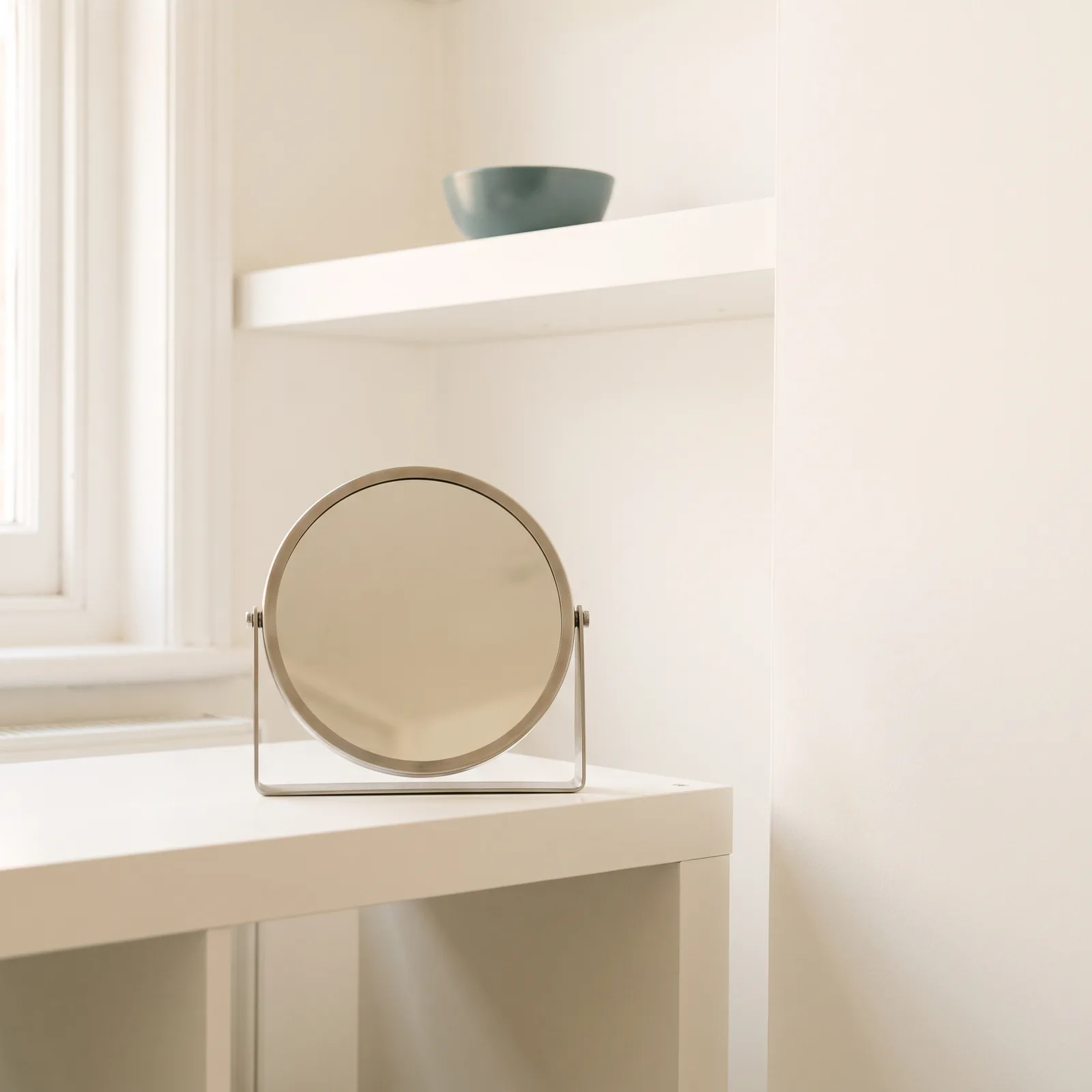 The round mirror on my white table in afternoon light